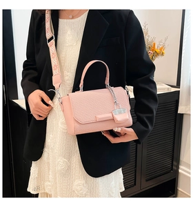 Pink handbag with woven texture and a decorative wide jacquard shoulder strap detail