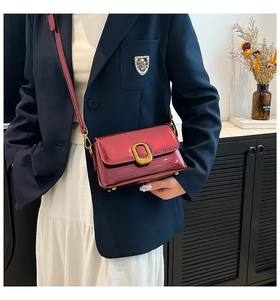 Détail du sac bandoulière en cuir verni rouge foncé avec fermoir doré vintage