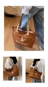 Detailed close-up of brown canvas tote bag with BUDBAO embroidery and cotton tassel detail
