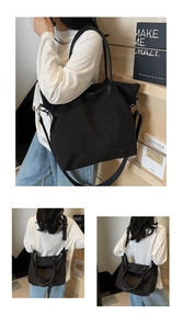 Détail d'un grand sac cabas noir en nylon montrant la texture et la bandoulière réglable