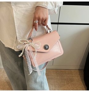 Sac à main rose brillant en cuir ciré avec fermoir argenté et breloque en perles et dentelle