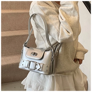 Détail d'un sac seau argenté métallisé avec fermoir tournant et boucle sur un mannequin