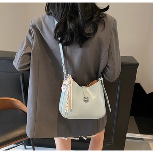 Detail of mint green patent leather crescent bag featuring silver G buckle and 1865 tag