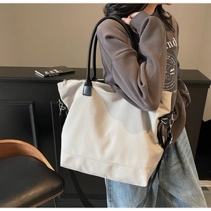 Détail du sac cabas minimaliste en toile avec coutures renforcées et finitions en cuir noir