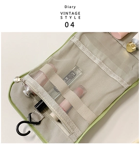 Detail view of foldable sage green toiletry bag with mesh pockets and hanging hook