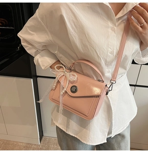 Sac bandoulière rose en cuir ciré avec fermoir rotatif et charm perle élégant