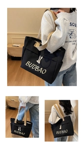 Detail of black canvas tote bag with BUDBAO embroidery and beige wide shoulder strap