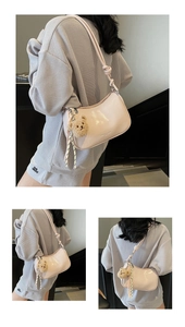 Detail of light pink patent leather crescent bag with cute brown plush bear accessory