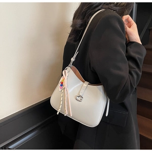 Detail of grey patent leather hobo bag with silver G buckle and colorful beaded charm