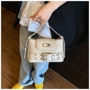 Détail du sac seau blanc cassé avec ceinture à oeillets argentés et fermoir métallique