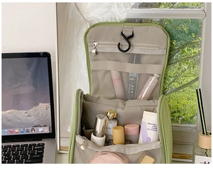 Detail view of fruit green hanging toiletry bag with mesh pockets and interior compartments