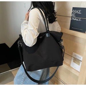 Grand sac cabas noir en nylon avec poignées en cuir dans un cadre de vie décontracté