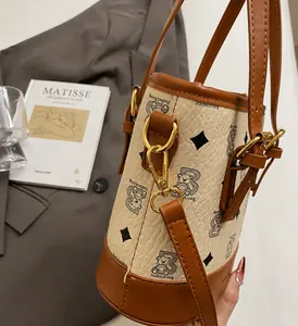 Close-up of premium bucket bag showing classic bear print and golden hardware details