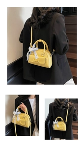 Detail of yellow mini Boston bag with ribbon bow and detachable crossbody strap