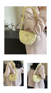 Close-up of a pale yellow textured cloud bag with a metal logo and puffy shoulder strap