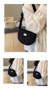 Close-up of black textured bubble fabric on a stylish crescent moon shaped shoulder bag
