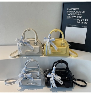 Detailed row of stylish Boston bags with bow accents and checkered ribbons in four colors