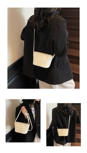 Détail de la texture tressée blanche sur un petit sac seau bandoulière en similicuir