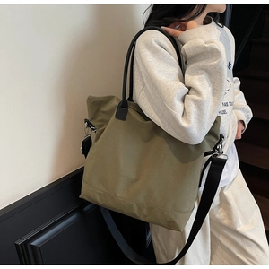 Sac fourre-tout en nylon vert olive avec bandoulière réglable noire sur un mannequin