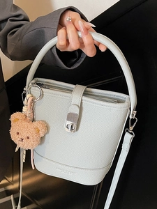 Elegant light blue bucket bag in litchi grain leather with brown teddy bear charm