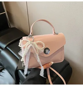 Sac à main rose brillant carré orné d'un grand nœud en perles et dentelle avec fermoir
