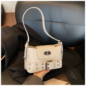 Détail d'un sac seau blanc cassé avec sangle à œillets décorative et fermoir rotatif