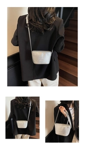 Détail d'un sac seau argenté à texture tressée avec une fine bandoulière croisée
