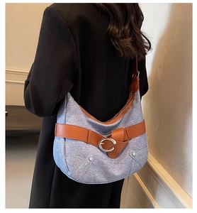 Modèle portant un sac d'épaule vintage en denim avec finitions cuir brun et boucle