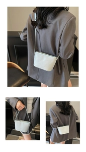 Texture tissée détaillée sur un sac seau bleu clair avec des garnitures métalliques élégantes