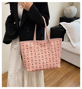 Detail of pink tote bag showing cartoon bear prints and golden rivet accents on leather
