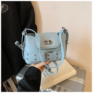 Détail du sac bandoulière style motard bleu clair avec œillets et boucle en métal
