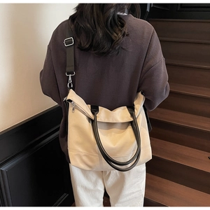 Photo de style de vie d'un grand sac cabas en toile blanc cassé porté avec une sangle réglable