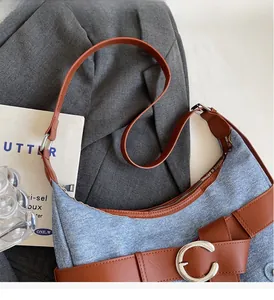 Détail du sac à bandoulière en jean vintage avec garniture en cuir brun et boucle en C