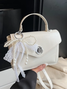 Sac à main élégant en cuir ivoire avec breloque nœud en perles et fermoir argenté
