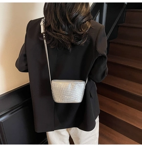 Détail du sac seau tissé argenté avec texture en cuir métallisé et bandoulière fine