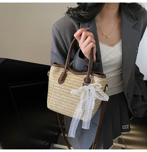 Detailed texture of straw weave bucket bag with leather trim and white lace bow decoration
