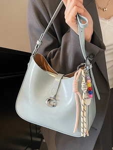 Light blue patent leather shoulder bag with metallic G buckle and decorative charms