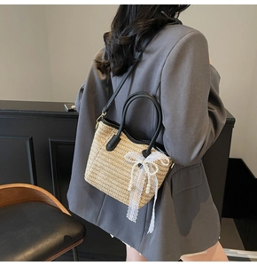 Detail view of woven straw bucket bag with white lace bow and elegant pearl charms