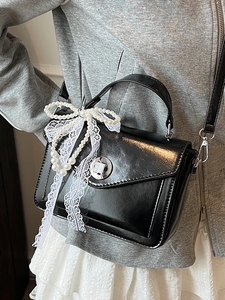 Sac à main en cuir noir brillant avec nœud en dentelle et perles et fermoir rotatif