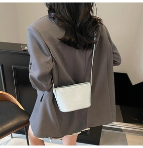 Détail du sac seau blanc avec texture tissée croisée et fine bandoulière en cuir