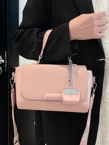 Pink woven texture crossbody bag with patterned wide strap and mini charm decor