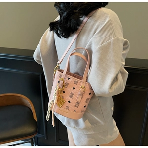 Pink monogram bucket bag detail with adjustable strap worn by model in waffle set