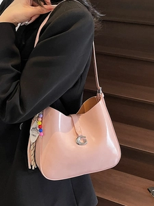 Glossy pink patent leather underarm bag with silver G buckle and tassel detail