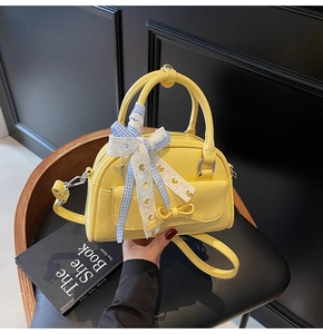 Detail of yellow PU leather Boston bag with bow tie and blue checkered lace ribbon
