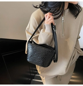 Vue détaillée du tissage noir sur le sac seau avec une finition en cuir élégante