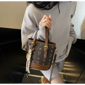 Detail of vintage brown monogram bucket bag with gold hardware and woven charm