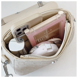 Top view of cream leather handbag interior showing large capacity and zipper pocket
