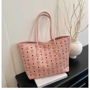 Detailed close-up of pink tote bag with bear pattern and textured faux leather surface