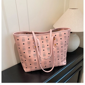 Detail shot of large pink tote bag with bear pattern and durable leather texture