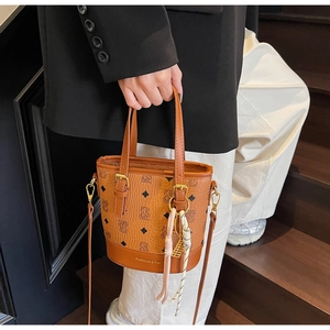 Close-up of brown bucket bag with monogram pattern and gold FASHION & YM branding